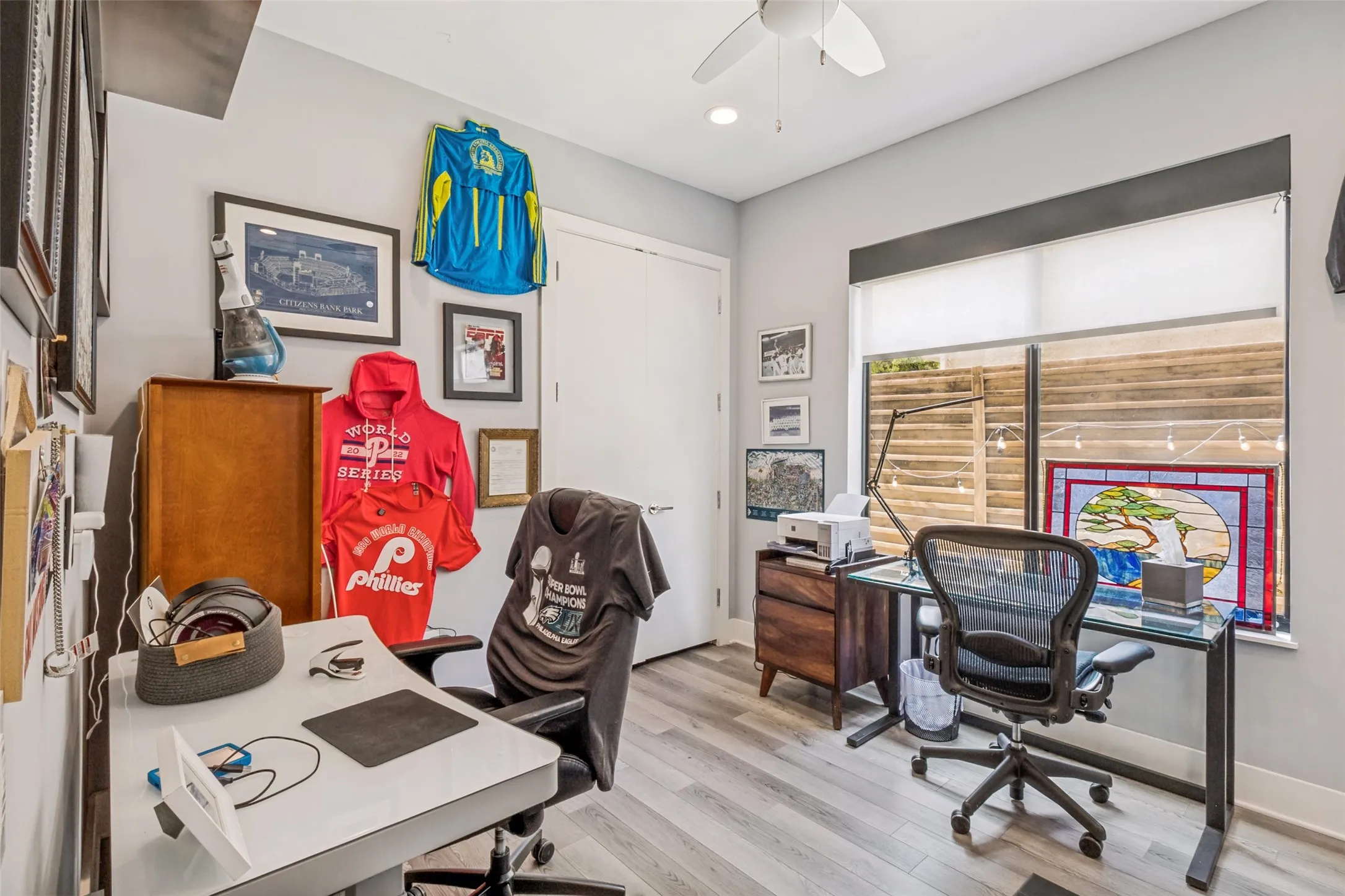 Bright interior space featuring light wood-finish flooring and a ceiling fan with integrated lighting