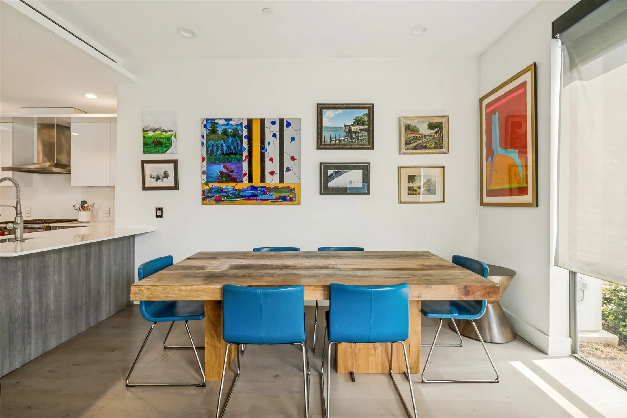 Open-concept dining area featuring a substantial wood table and light-toned flooring