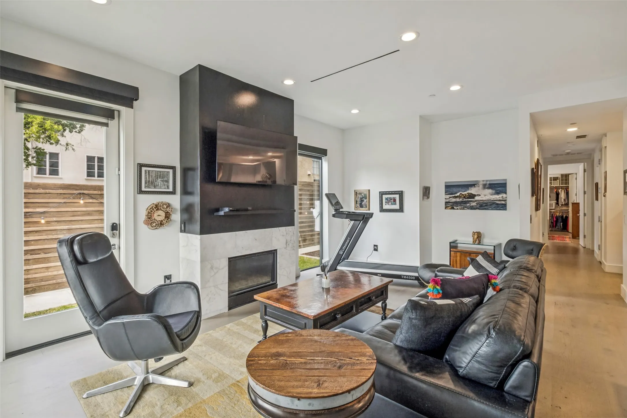 Living area featuring a floor-to-ceiling fireplace with a dark finish mantel and a light-colored hearth