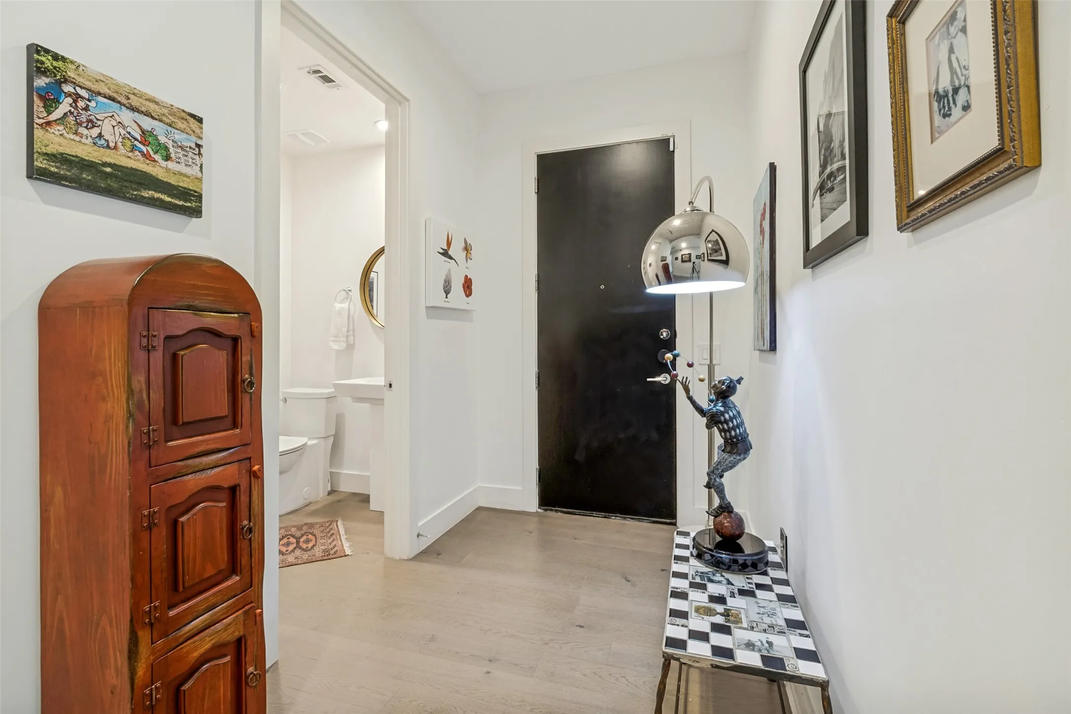 Inviting foyer featuring modern finishes and a convenient powder bath.