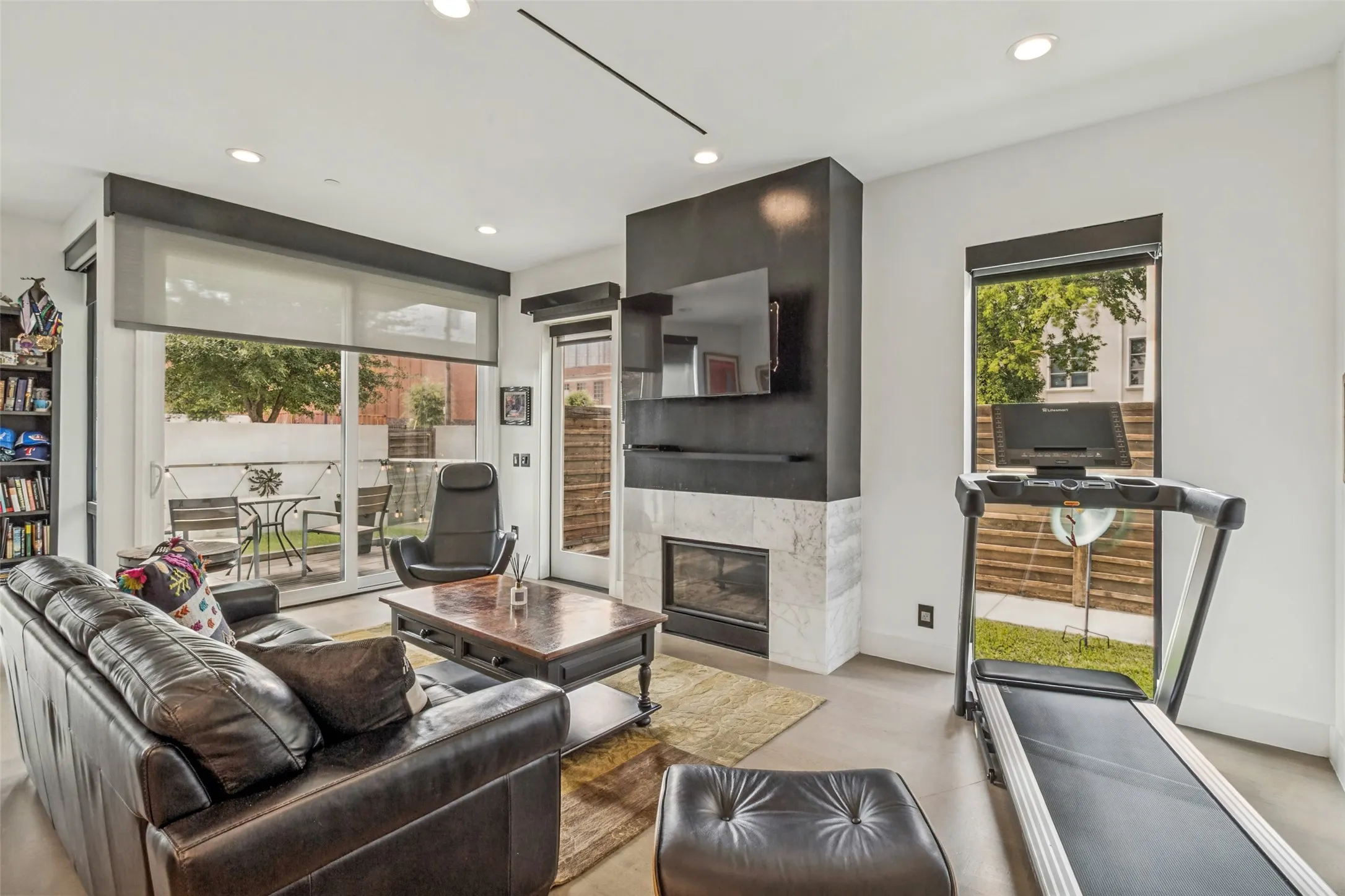 Living space featuring a built-in fireplace with a stone surround, recessed lighting, and light-colored flooring