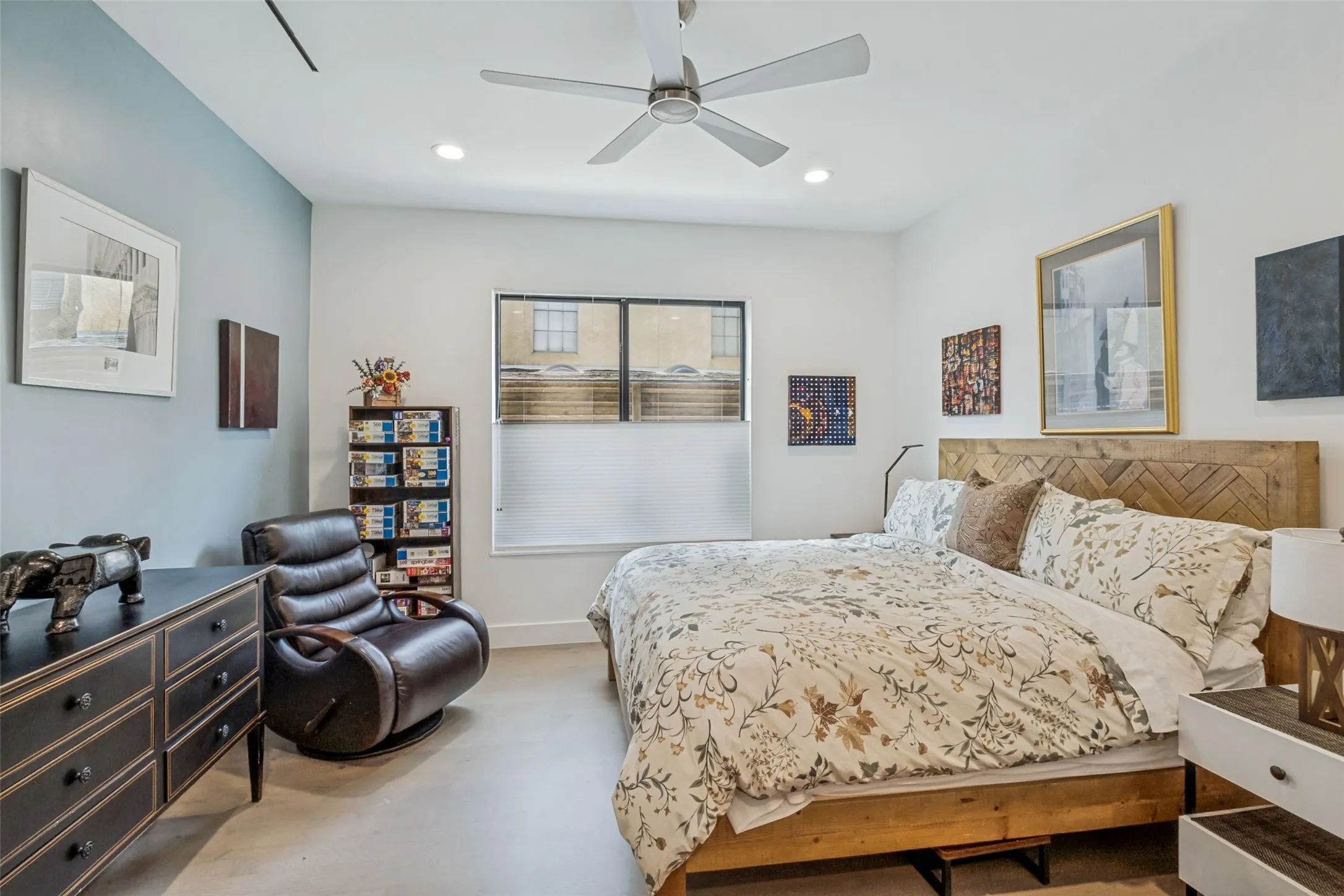 Bedroom featuring light-colored flooring and a contrasting accent wall