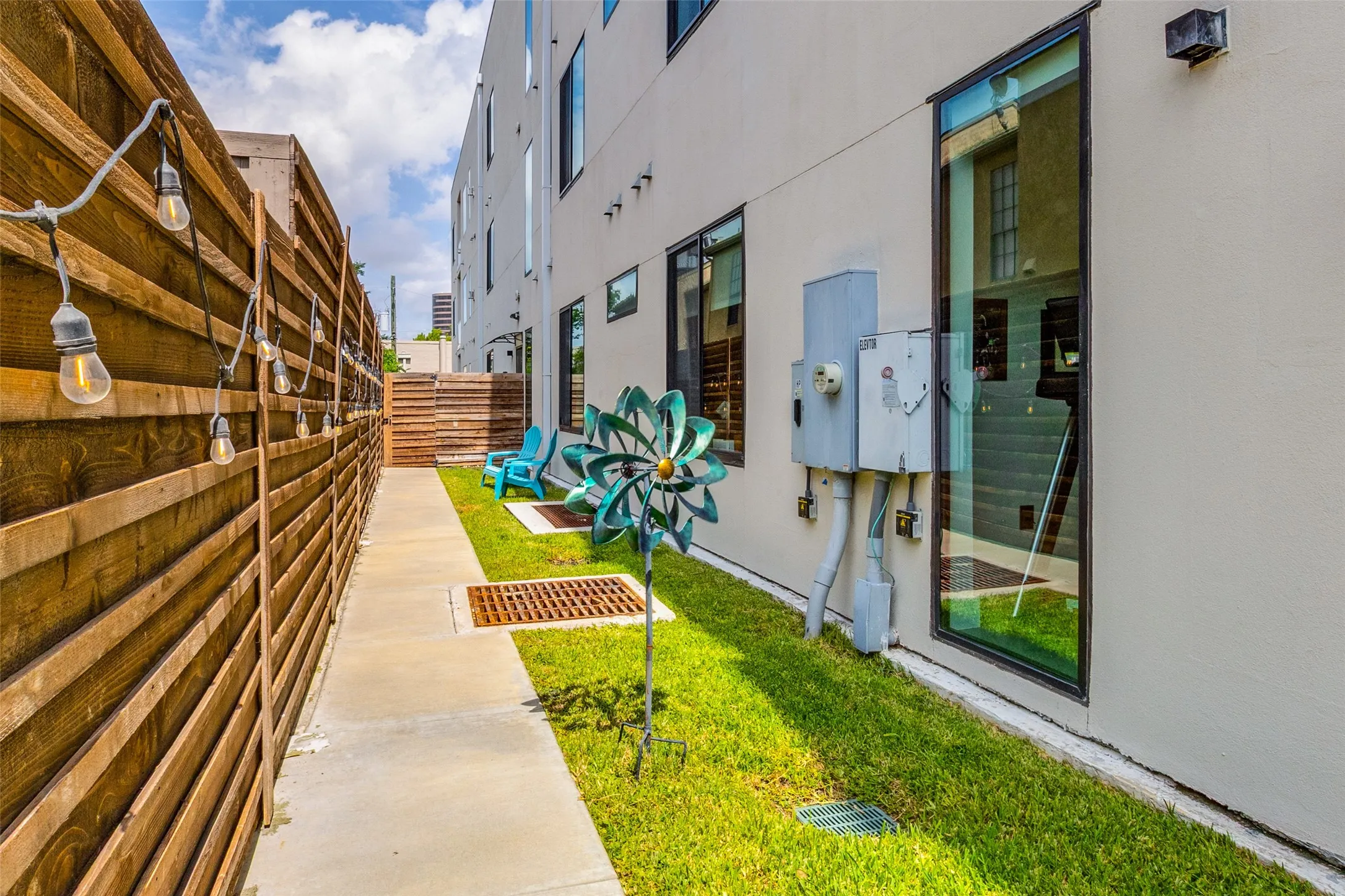 Private, fenced outdoor space with a grassy yard, patio seating area, and walkway—perfect for relaxing, entertaining, or enjoying a low-maintenance outdoor lifestyle.