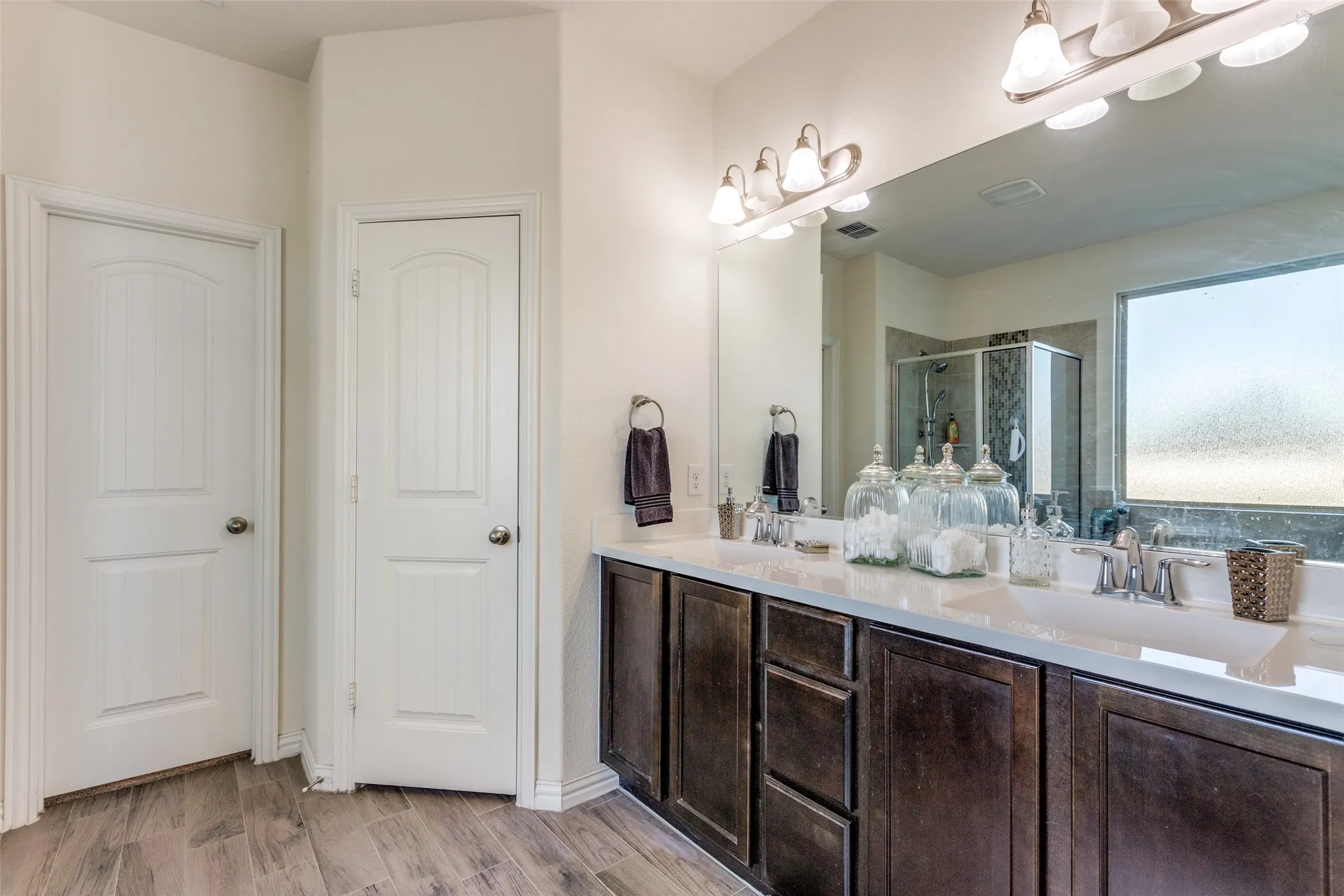 Bathroom featuring a shower with door, hardwood / wood-style floors, and vanity
