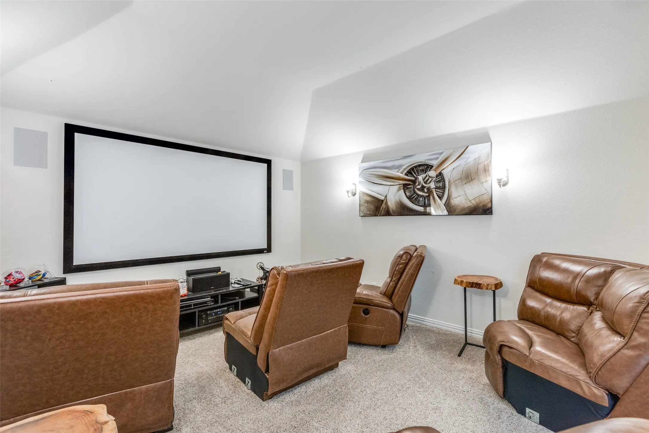 Carpeted home theater featuring vaulted ceiling