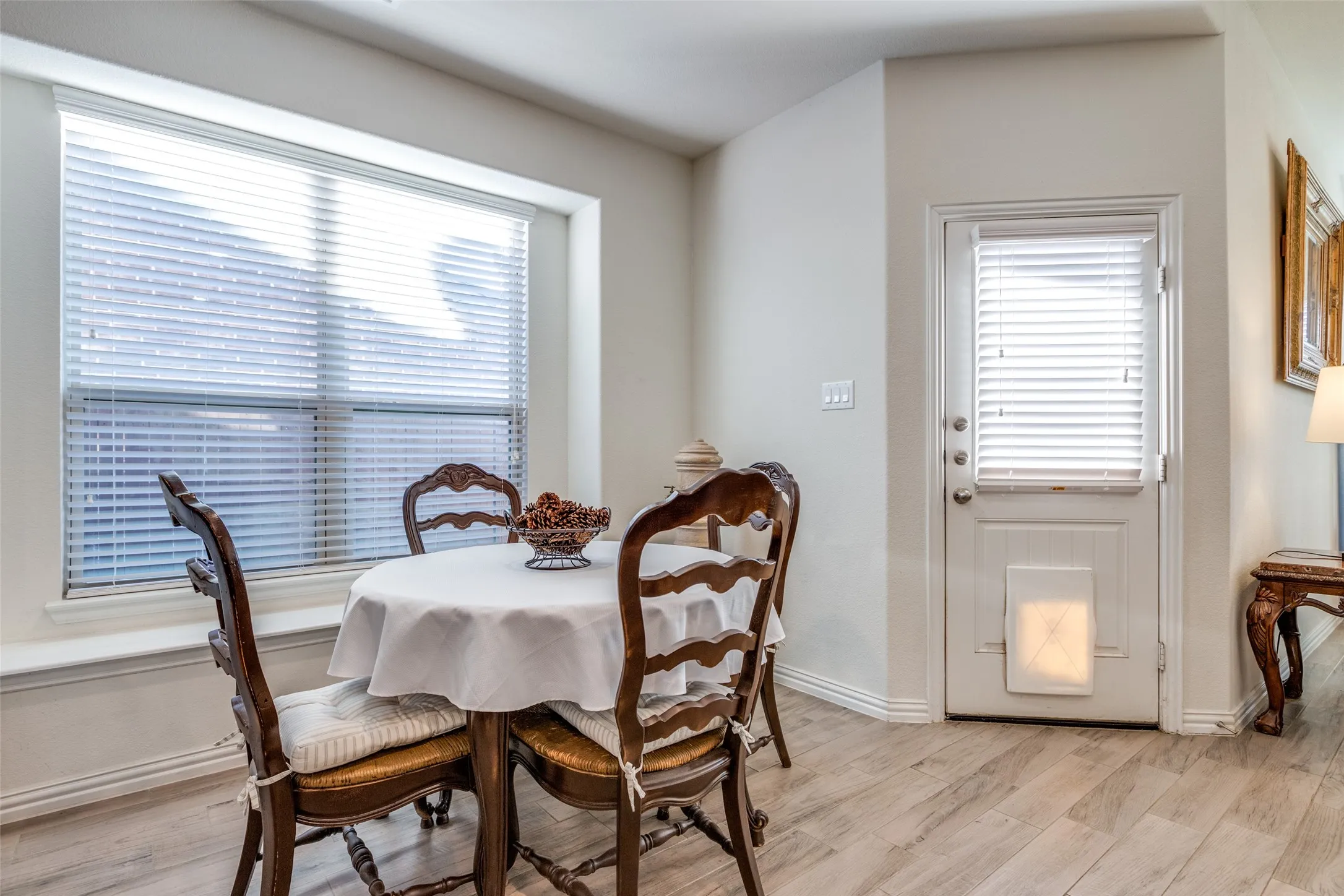 Dining space with a healthy amount of sunlight and light hardwood / wood-style flooring