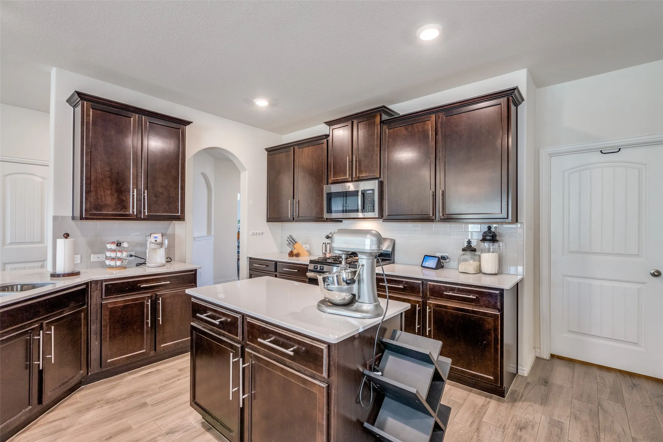 Kitchen featuring appliances with stainless steel finishes, dark brown cabinetry, and light hardwood / wood-style floors