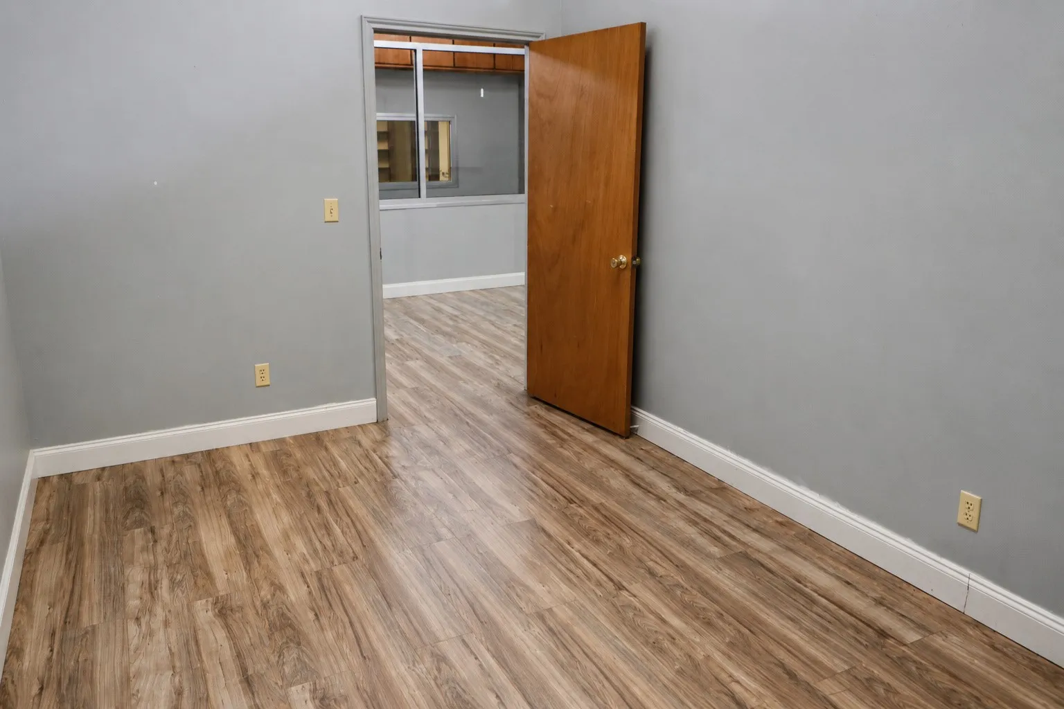 Wood-finish flooring throughout, complemented by light grey walls and white trim