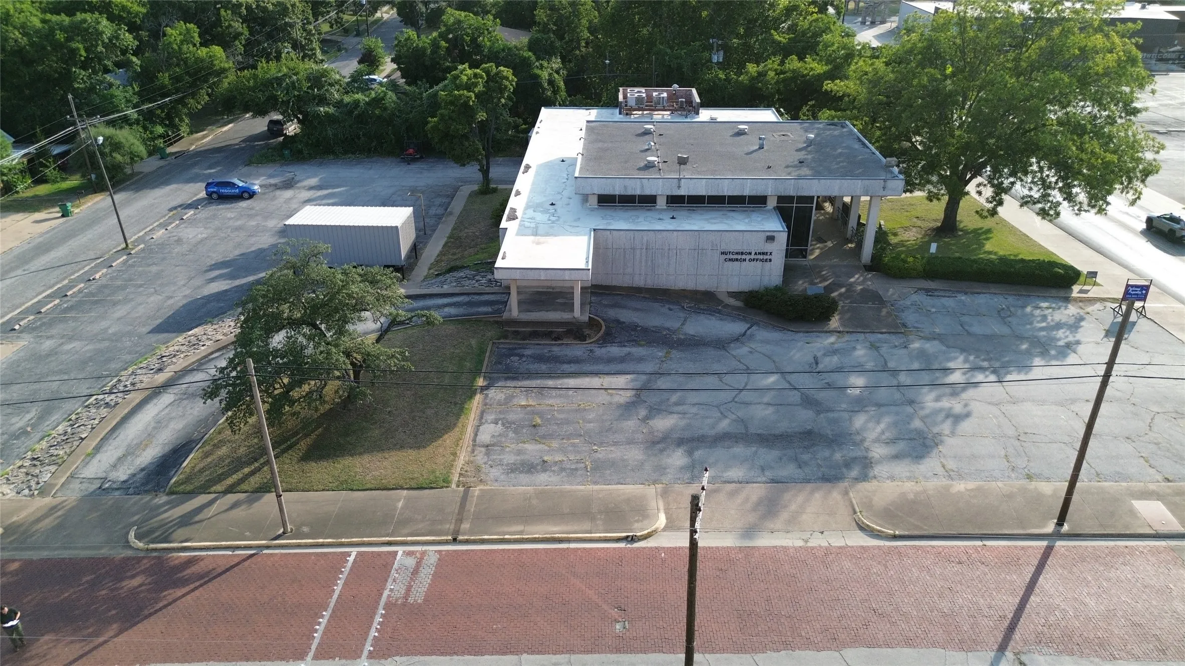Single-story commercial building featuring a flat roof and a paved parking area