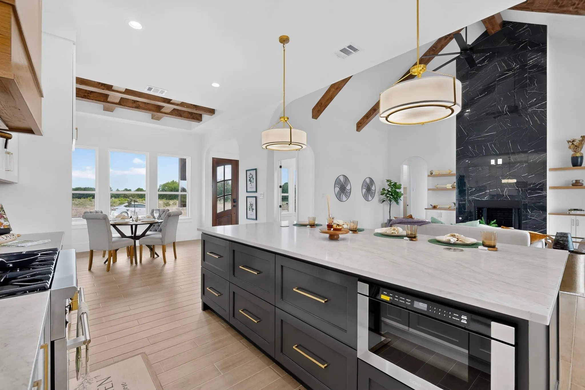 Gourmet kitchen with a large central island, light-toned countertop, and integrated microwave drawer