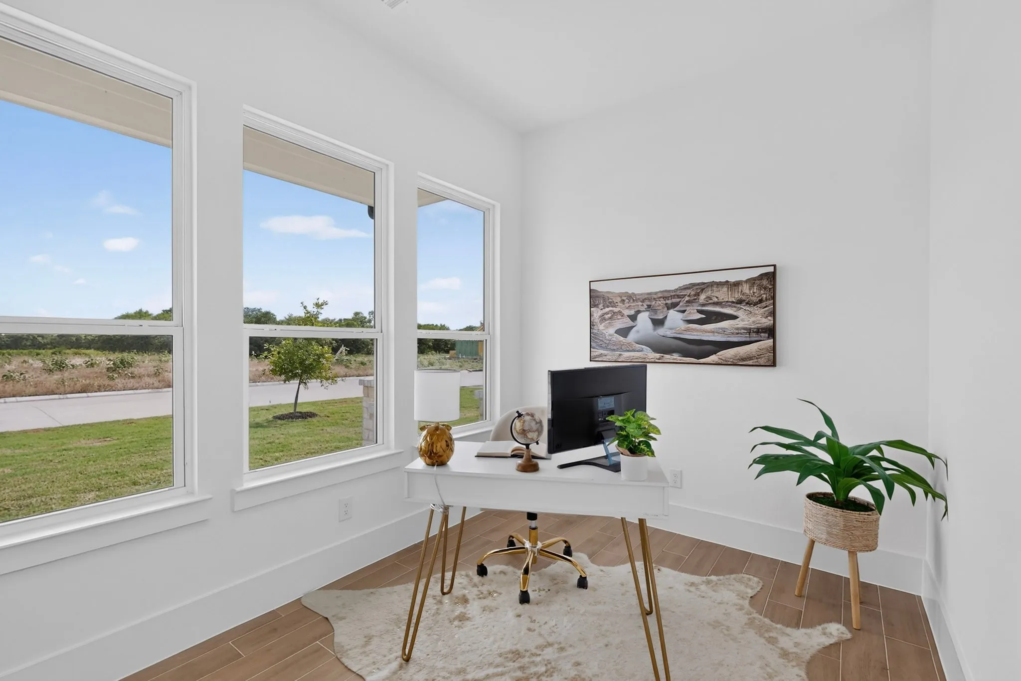 Bright interior space featuring multiple windows, wood-finish tile flooring, white walls, and white trim