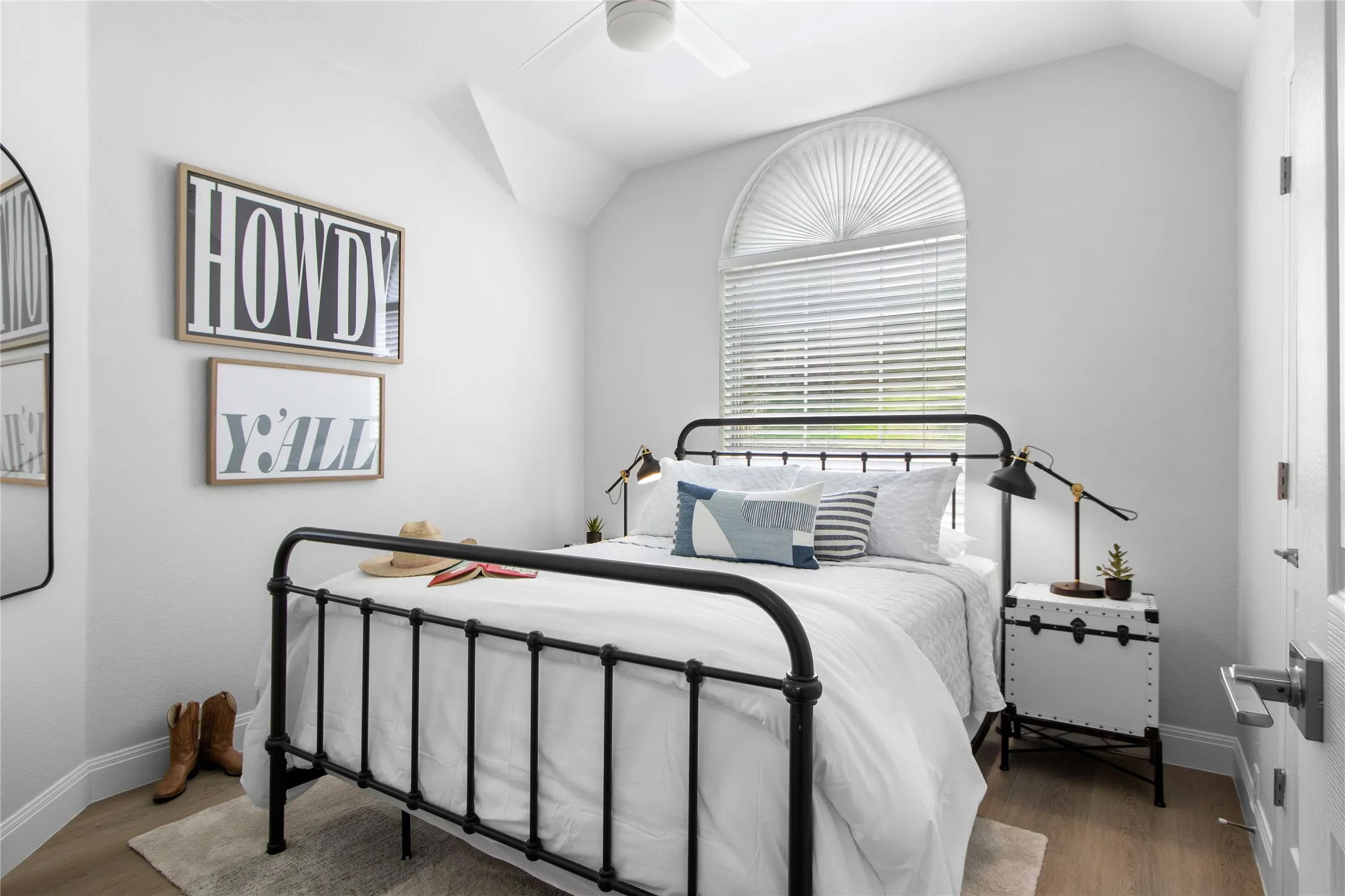 Bedroom featuring an arched window with blinds, wood-finish flooring, and a ceiling fan