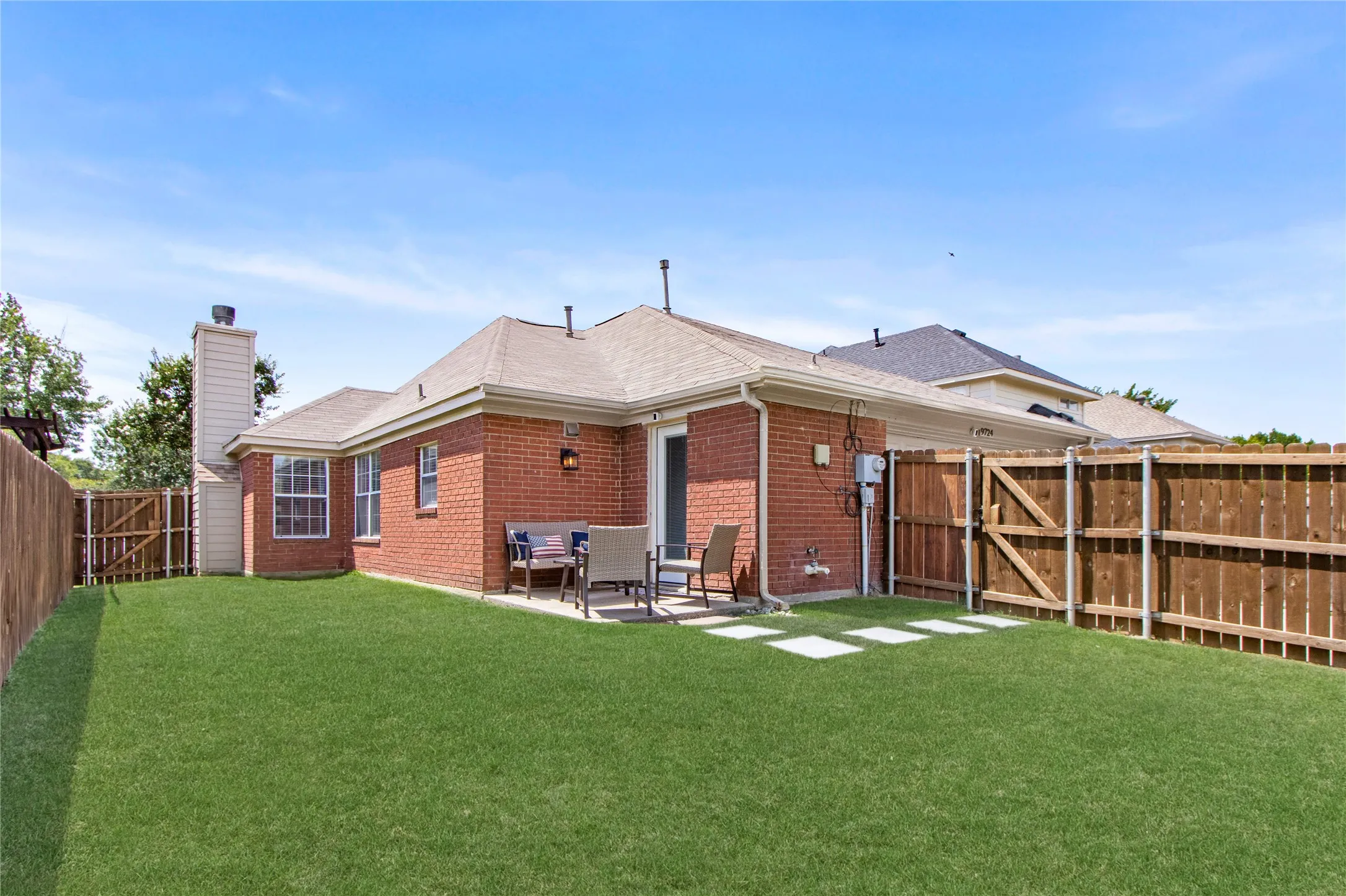 Private backyard featuring a brick exterior, concrete patio, and a wood privacy fence