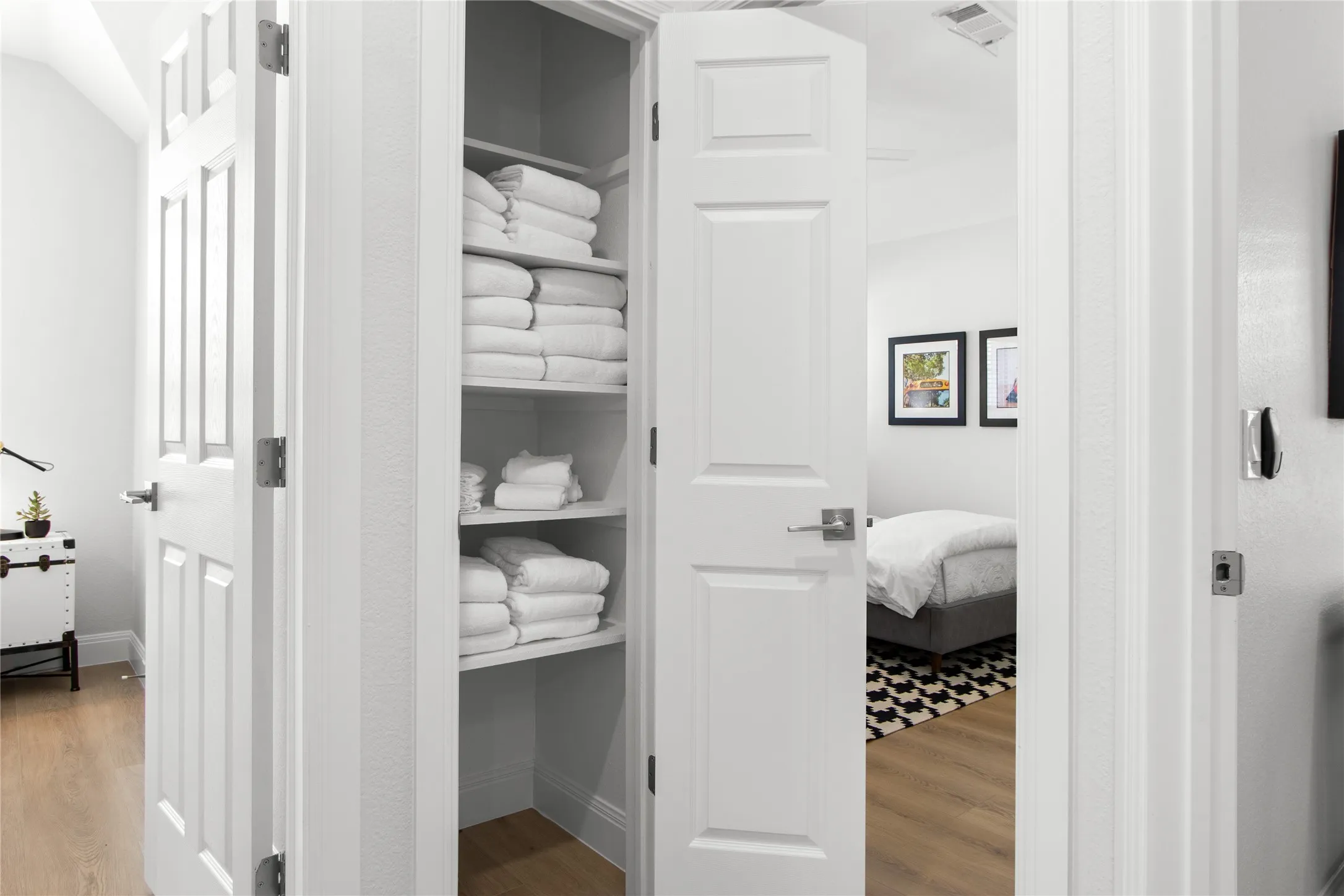 Built-in linen closet with multiple shelves, featuring white paneled doors and brushed nickel hardware