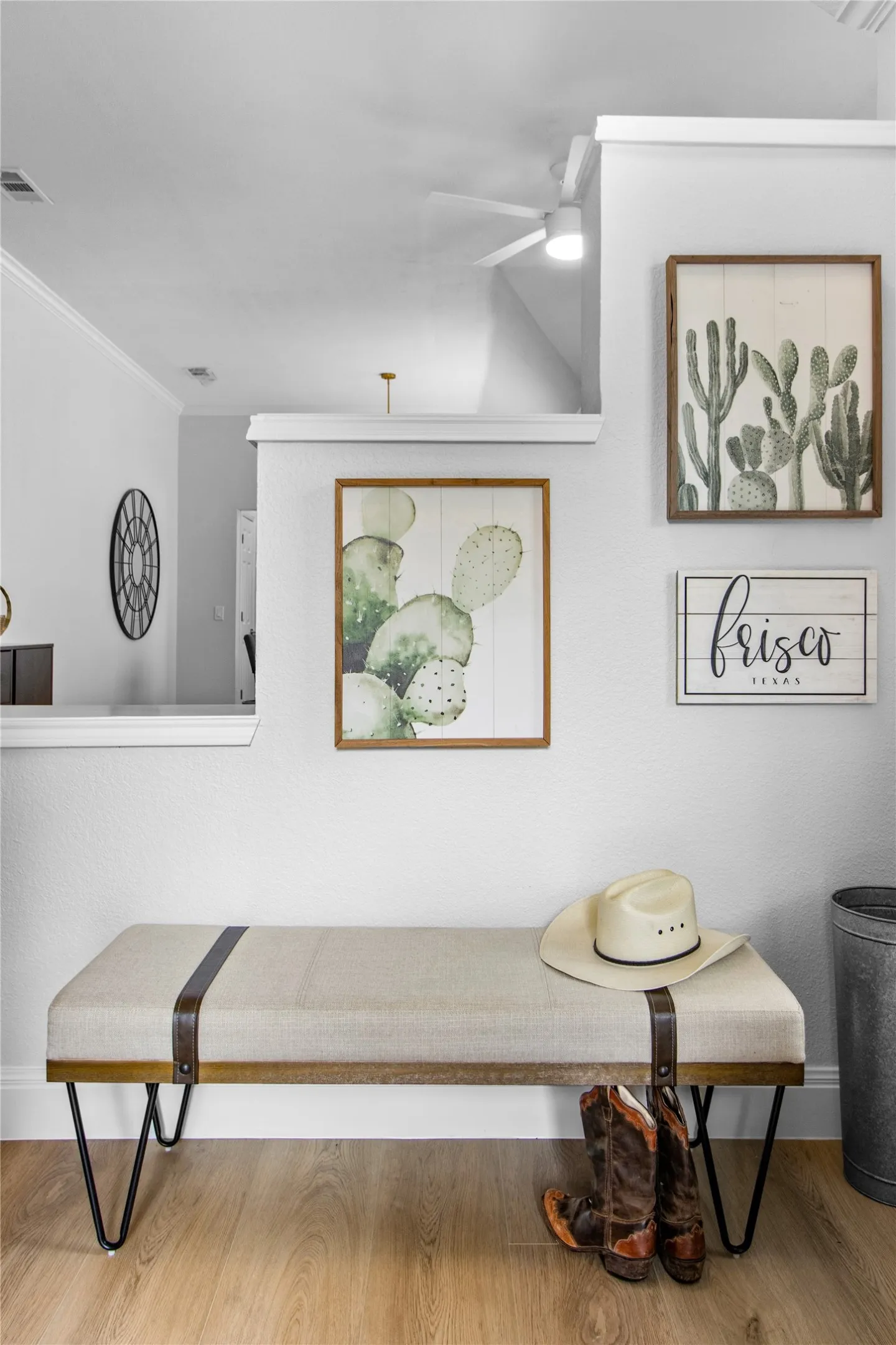 White walls with decorative trim, wood-finish flooring, and a ceiling fan with integrated lighting