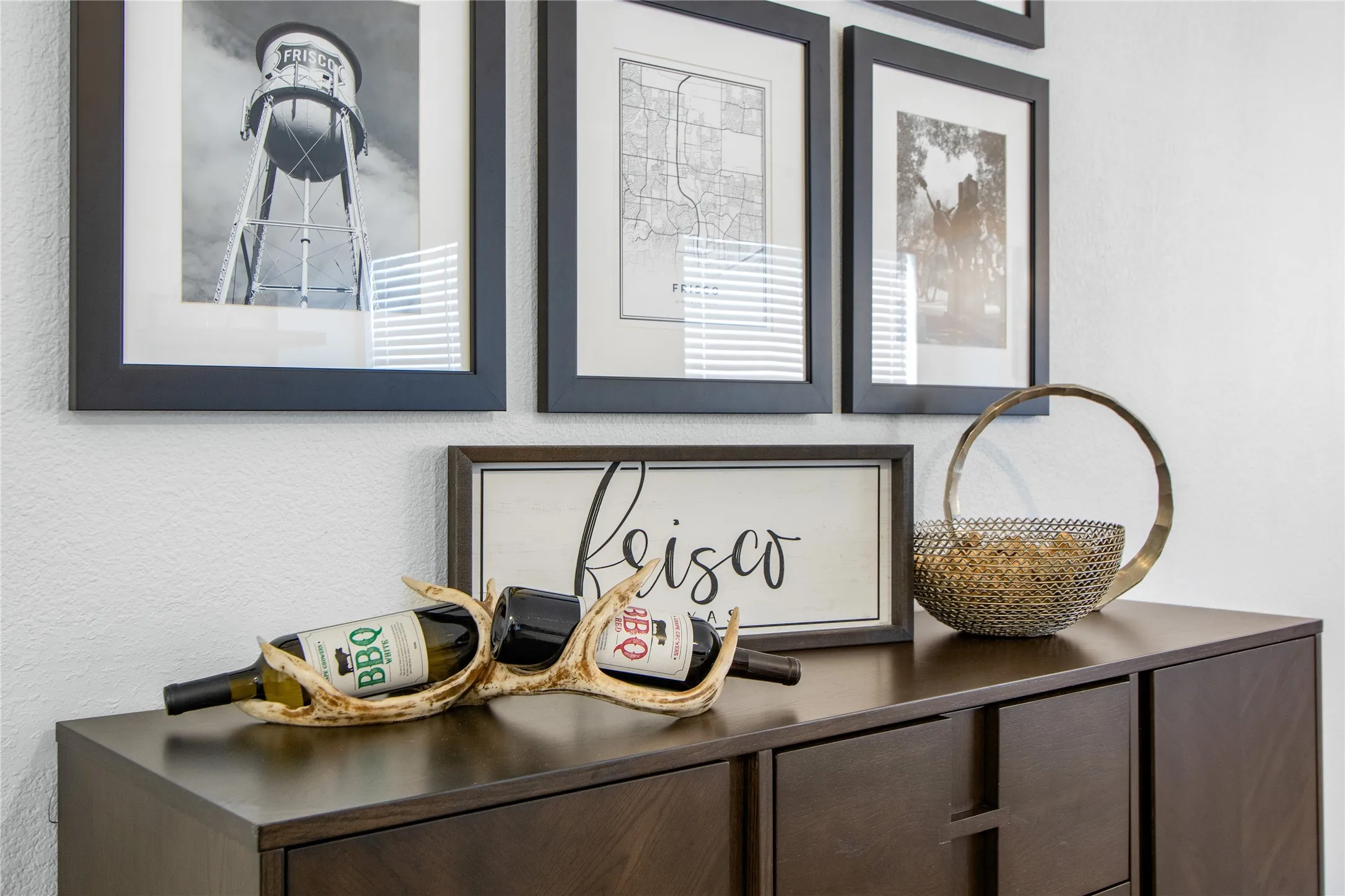 Built-in dark wood-finish cabinetry with white textured walls and black framed artwork