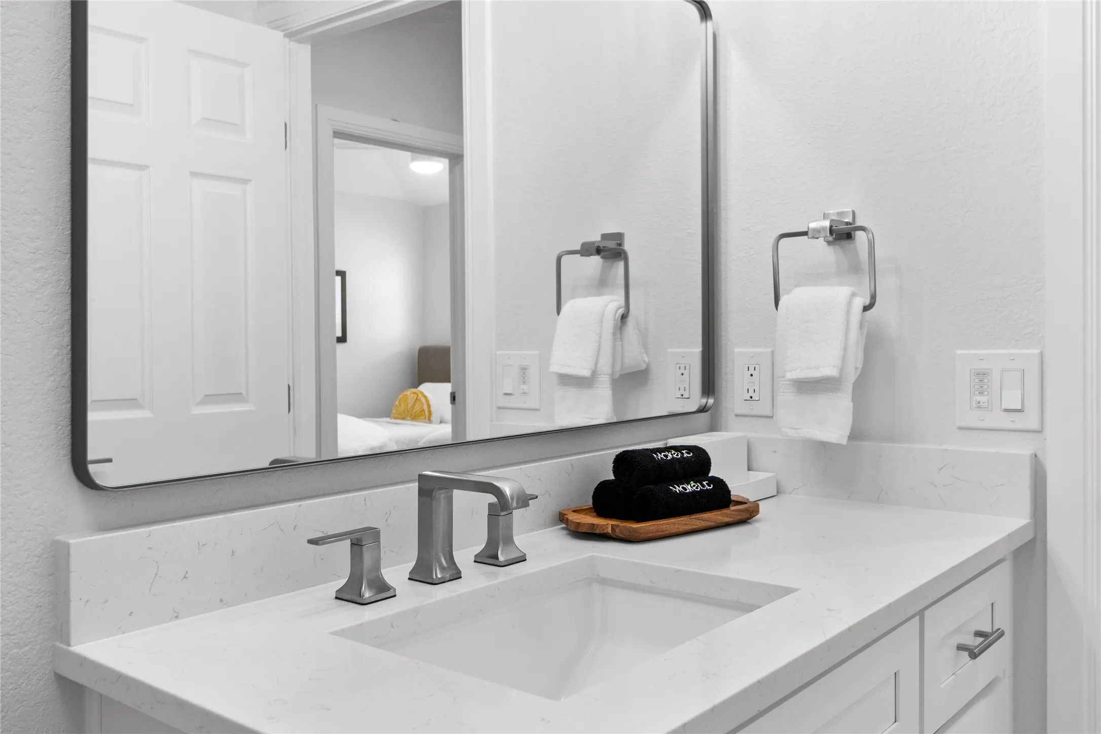 Bathroom vanity featuring a rectangular undermount sink, a light-toned countertop, and brushed nickel fixtures