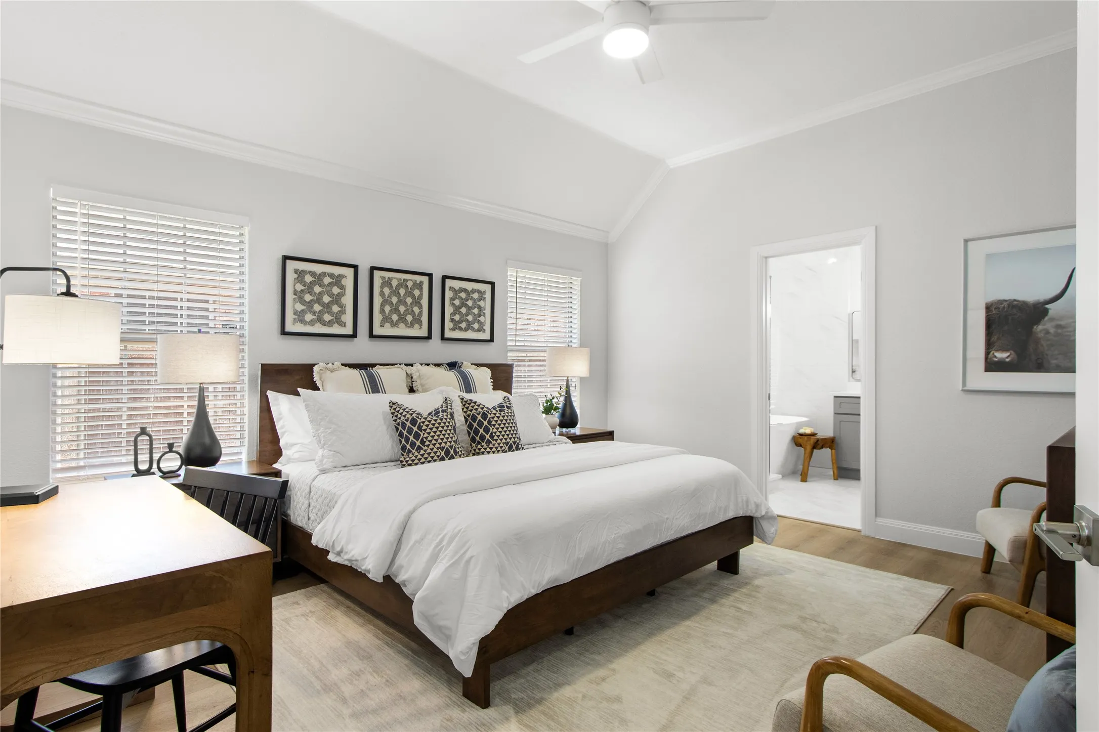 Vaulted ceilings featuring a ceiling fan, light wood-finish flooring, and white wall finishes