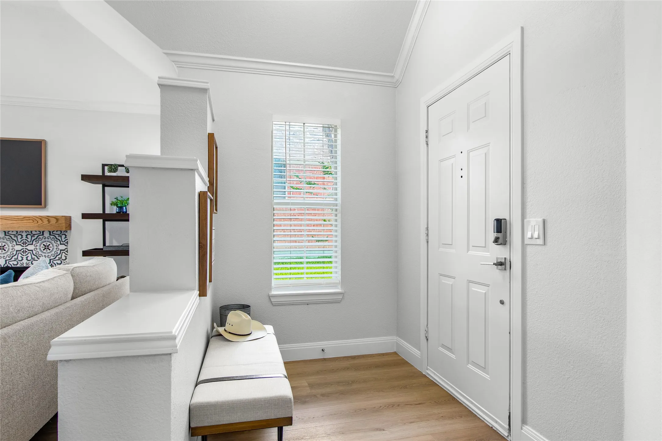 Entryway featuring wood-finish flooring and crown molding