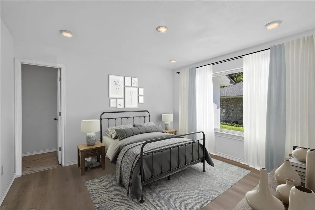 Bedroom featuring wood-finish flooring, recessed lighting, and a window with a garden view