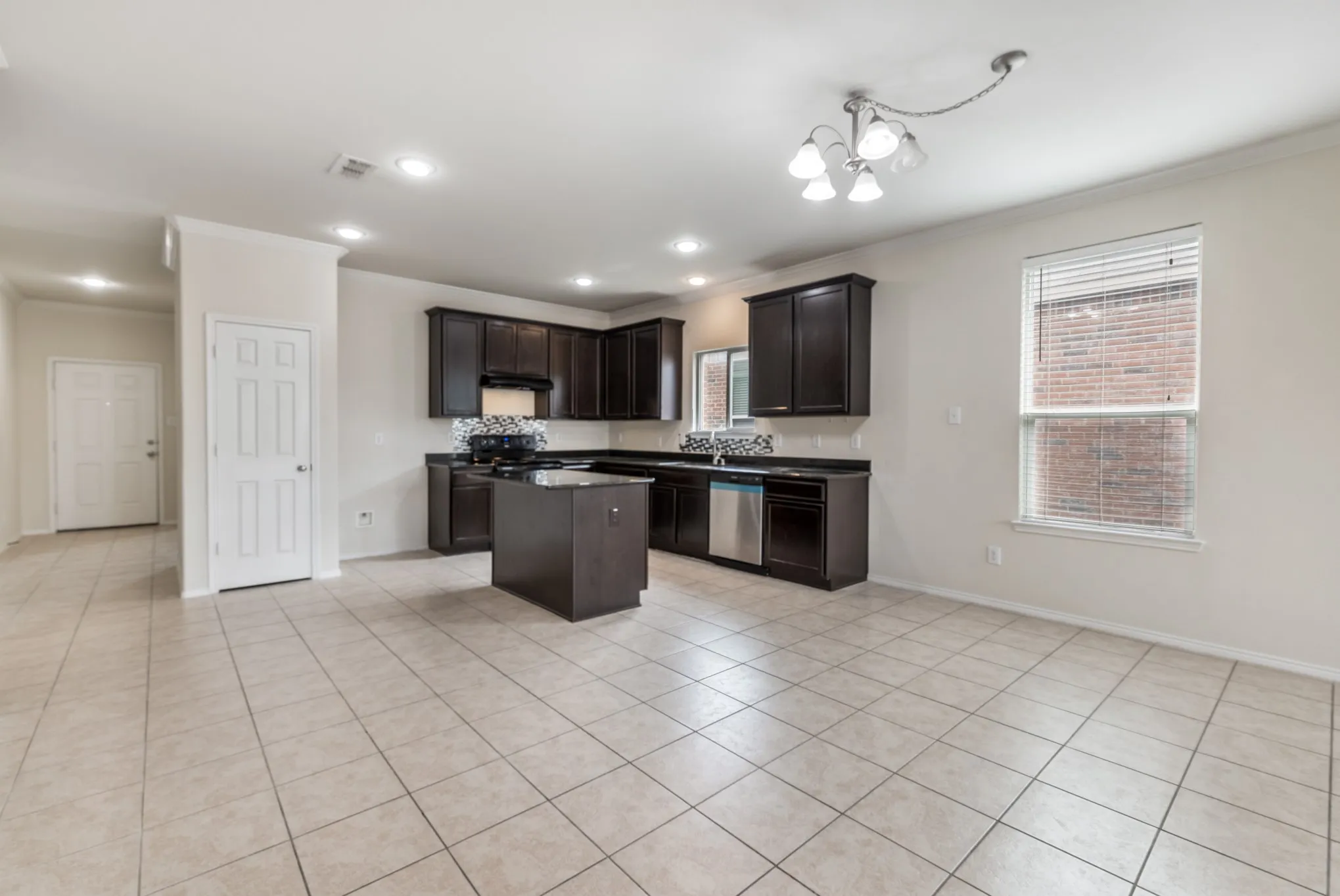 Spacious kitchen featuring dark wood cabinetry, a central island, and stainless steel appliances