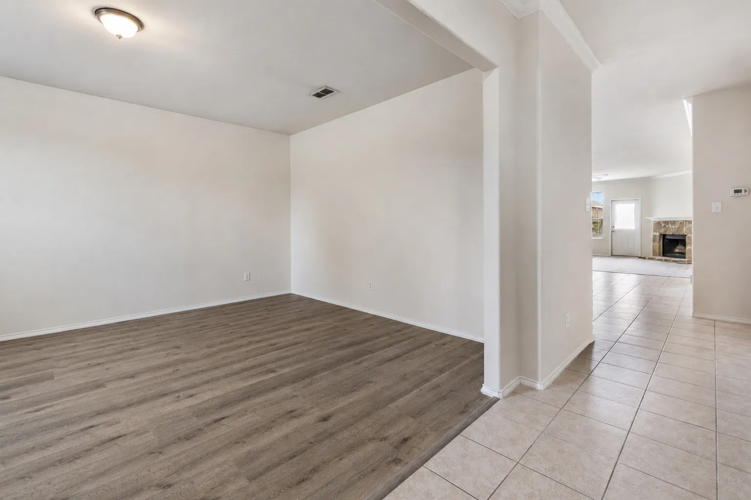 Interior space featuring wood-finish flooring, white walls, and a ceiling-mounted light fixture