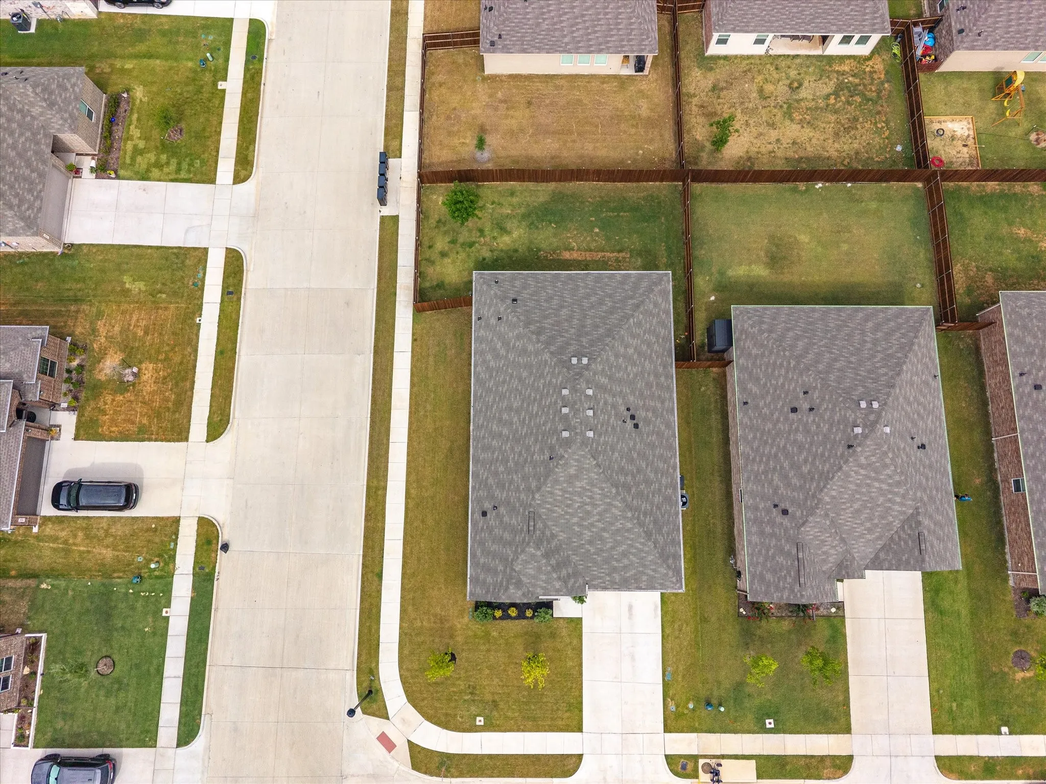 Pitched roofline residential property featuring a concrete driveway and sidewalk access