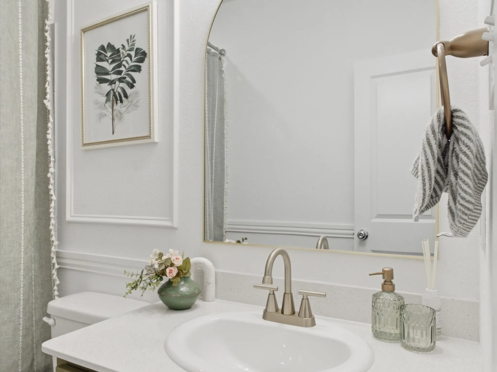 Bathroom vanity featuring a brushed nickel faucet and an integrated sink