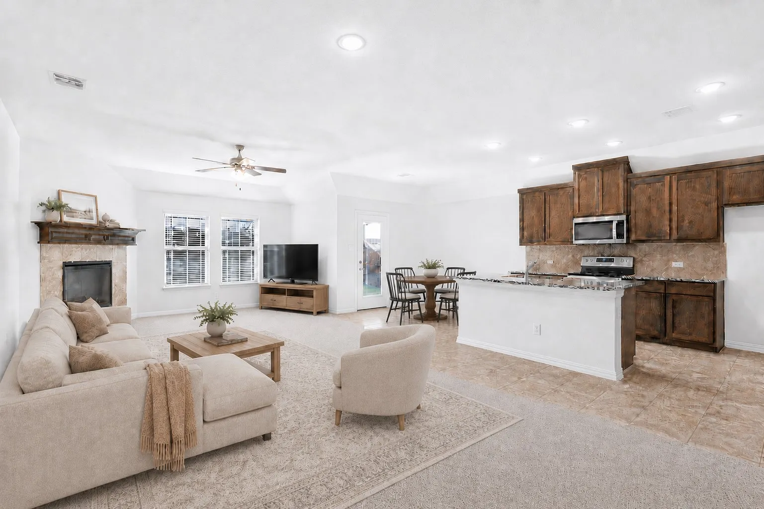 Open-concept living space featuring a fireplace with stone surround and wood mantel, recessed lighting, and a ceiling fan