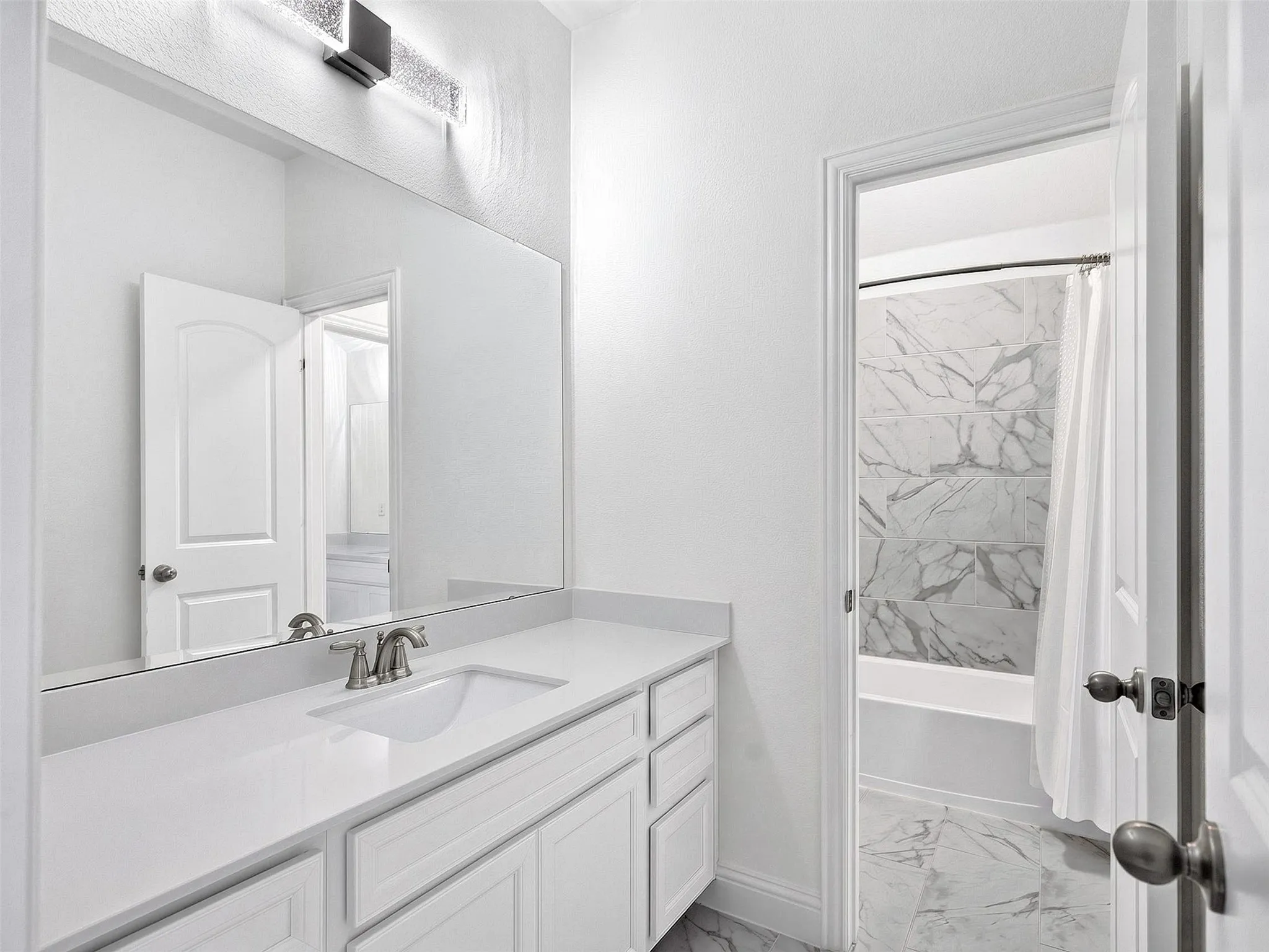 Jack & Jill Bathroom featuring a quartz countertop, integrated sink, and brushed nickel faucet