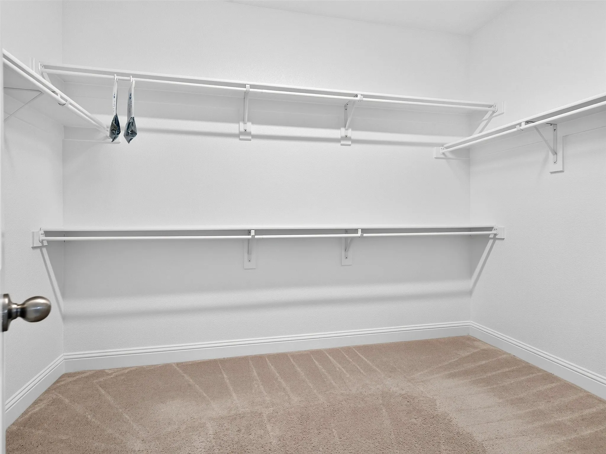 Spacious closet featuring white wire shelving and hanging rods