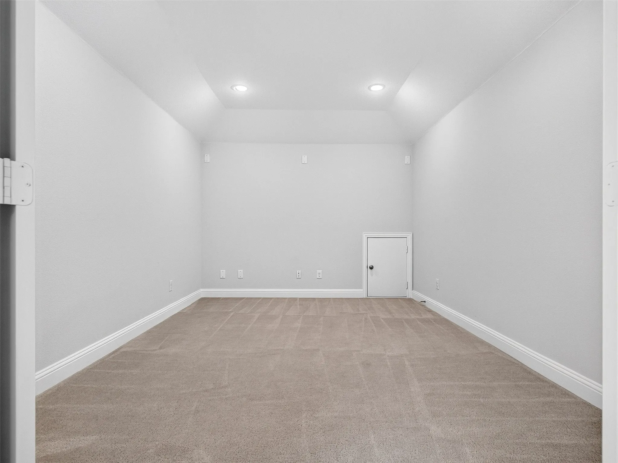 Spacious media room with vaulted ceilings, recessed lighting, and a clean, modern finish