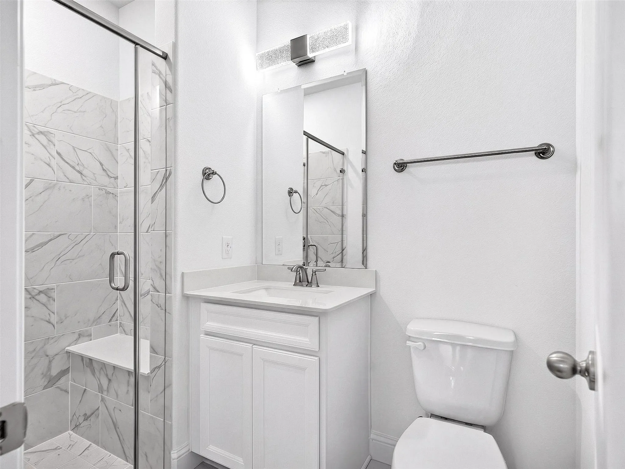Downstairs Bathroom featuring a modern glass-enclosed shower, sleek vanity, and bright contemporary finishes