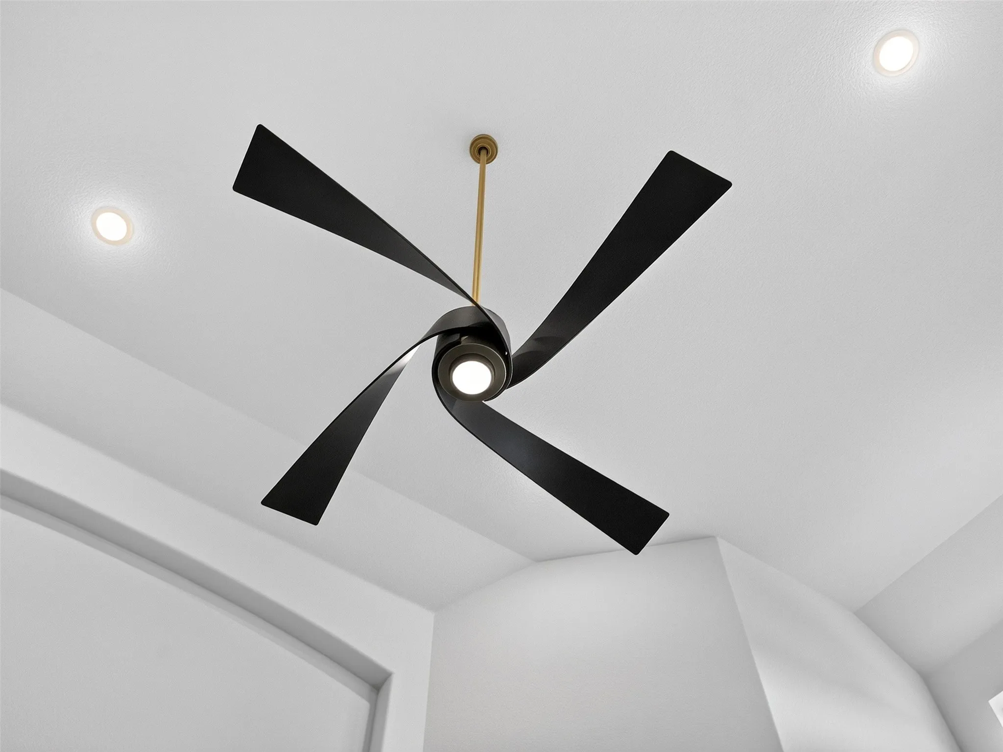 Modern ceiling fan with sleek black blades, gold downrod, and integrated lighting for a contemporary touch