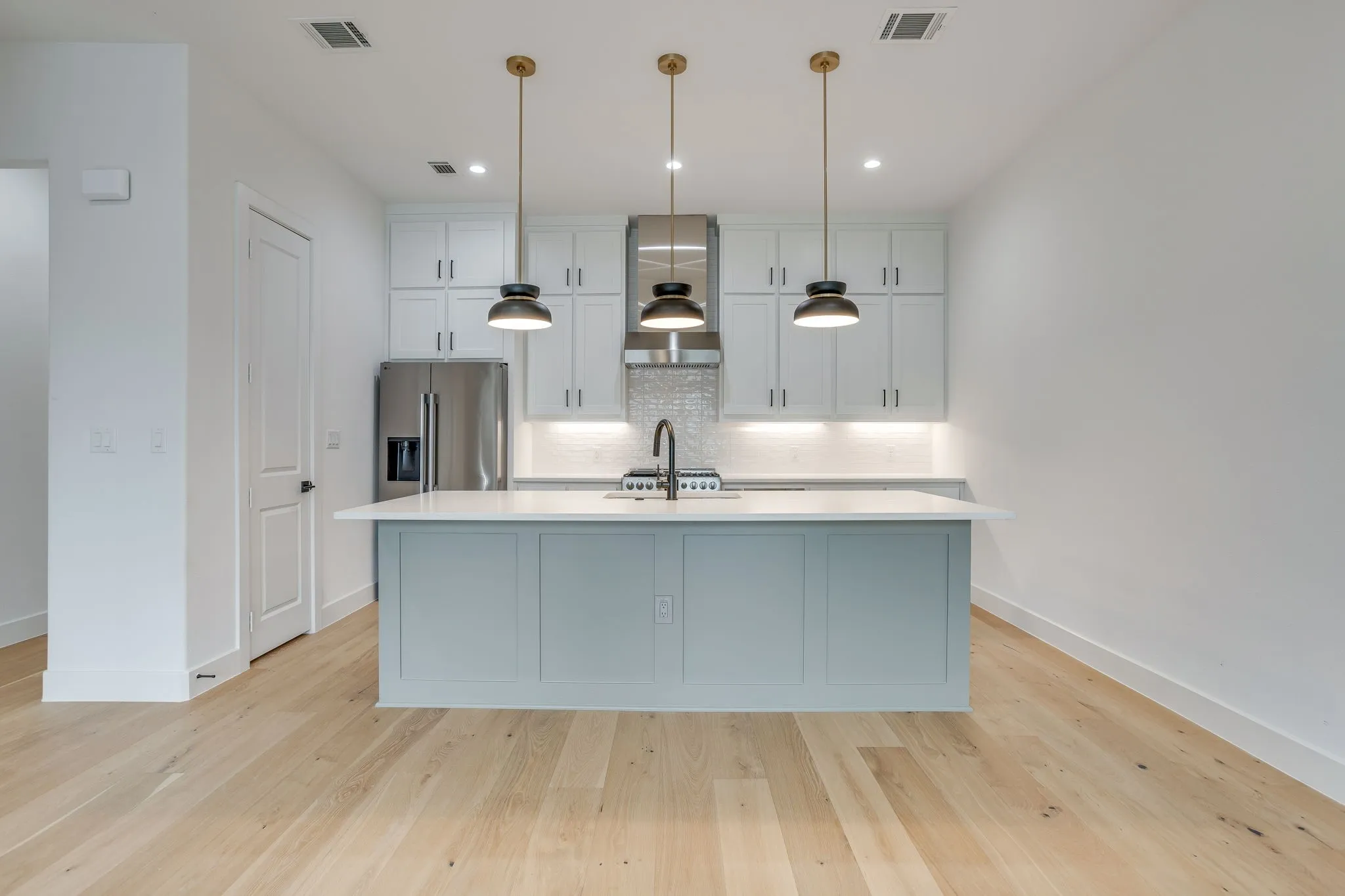 Contemporary kitchen featuring a light blue island with a white countertop
