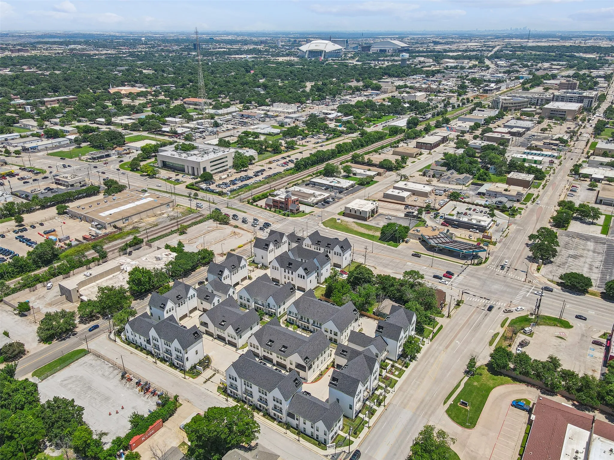 New construction townhomes featuring light-colored facades and dark-pitched roofs