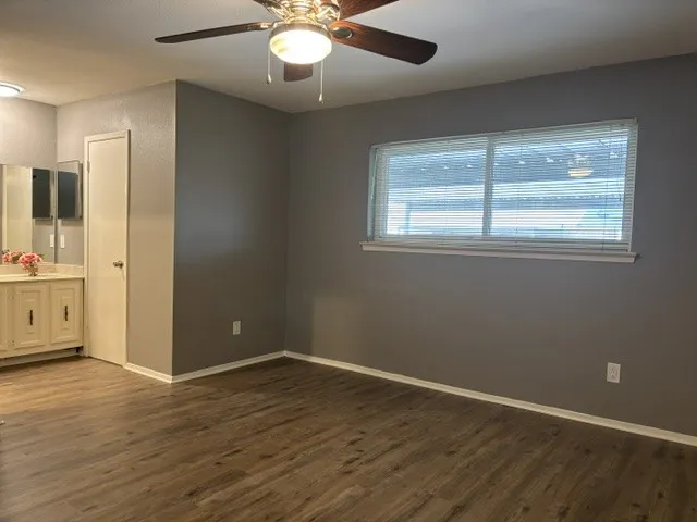 Generous primary bedroom with fresh paint, ceiling fan, blinds, walk in closet and full bath