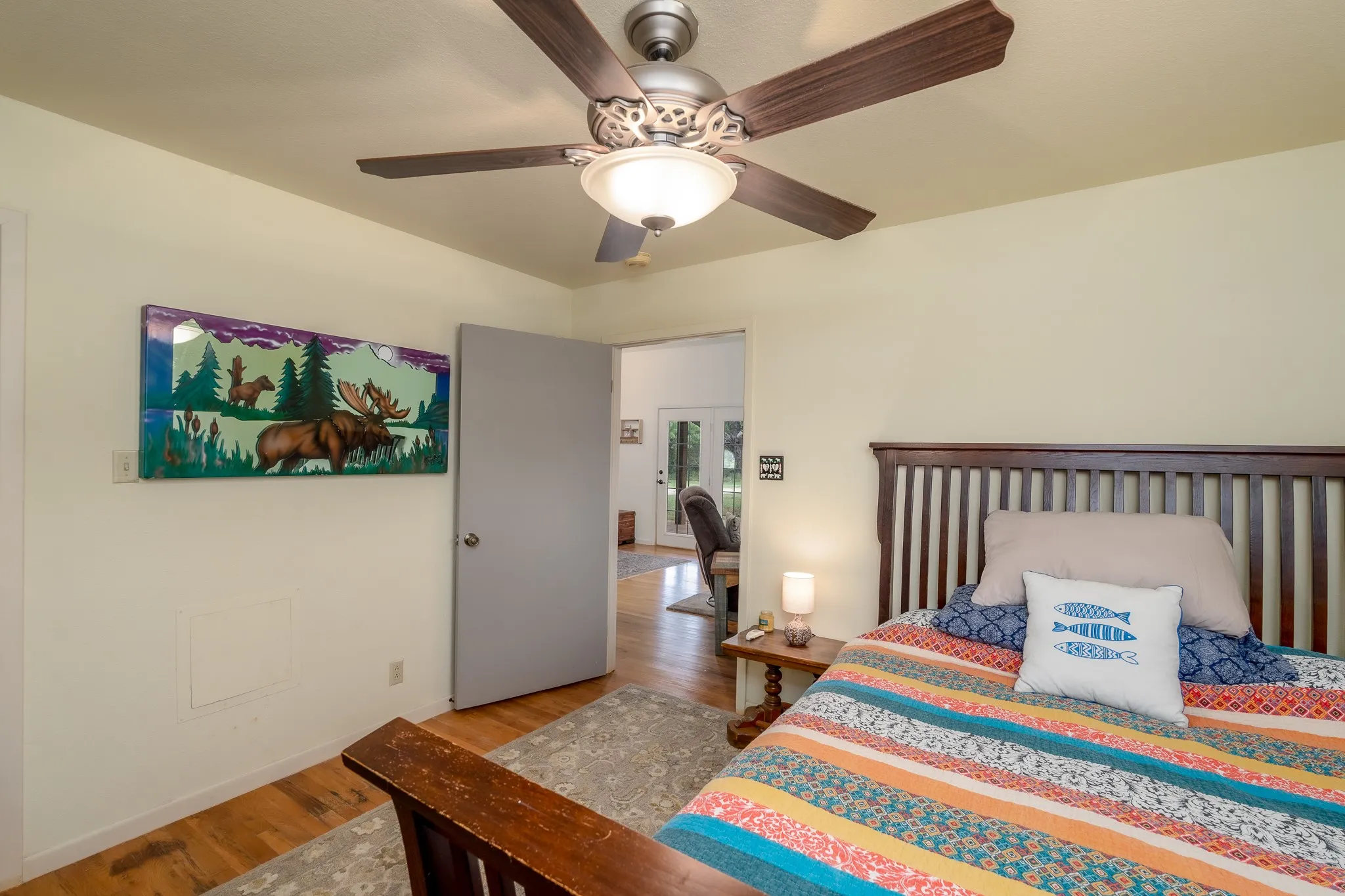 Wood-finish flooring with a ceiling fan featuring a light fixture