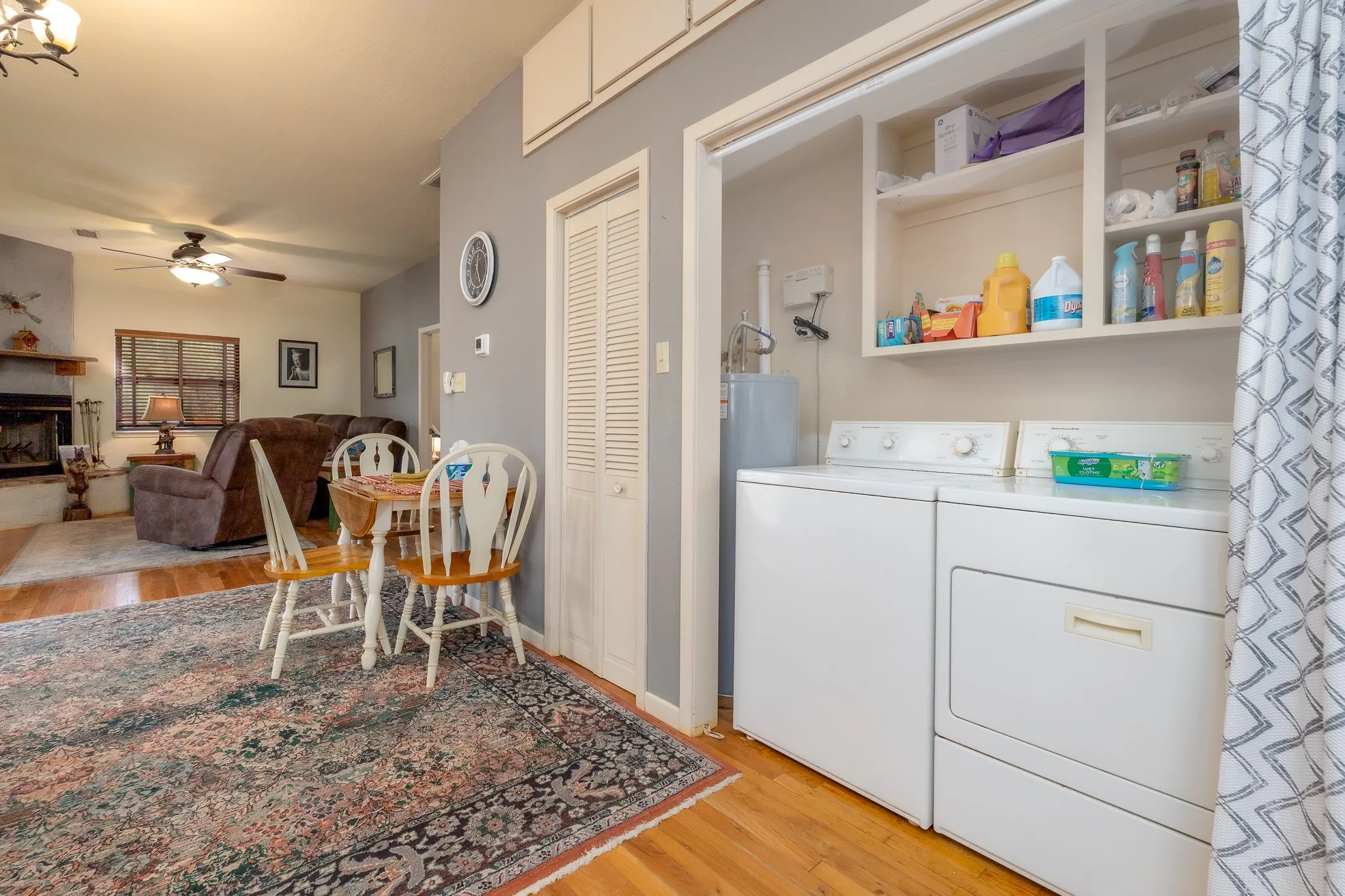 Dedicated laundry area featuring a washer and dryer, open shelving, and wood-finish flooring