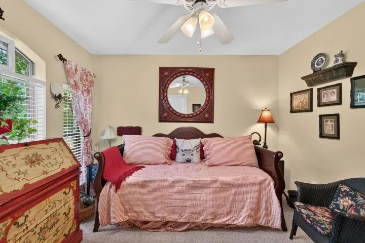 Room featuring a ceiling fan, a window with plantation shutters, and light-colored walls
