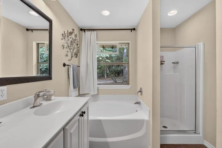 Bathroom featuring a single vanity with a white countertop, an integrated sink, and a framed mirror