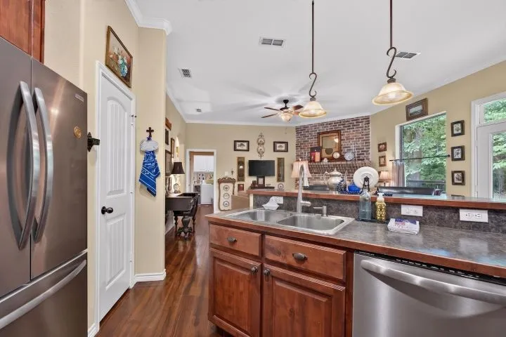 Kitchen featuring a double basin stainless steel sink, dark wood-finish cabinetry, and stainless steel appliances