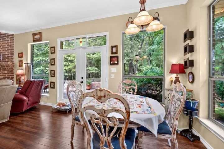 Dining area featuring wood-finish flooring, a decorative chandelier, and extensive fenestration