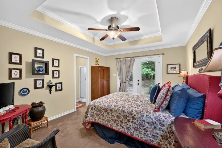 Tray ceiling with crown molding and a ceiling fan