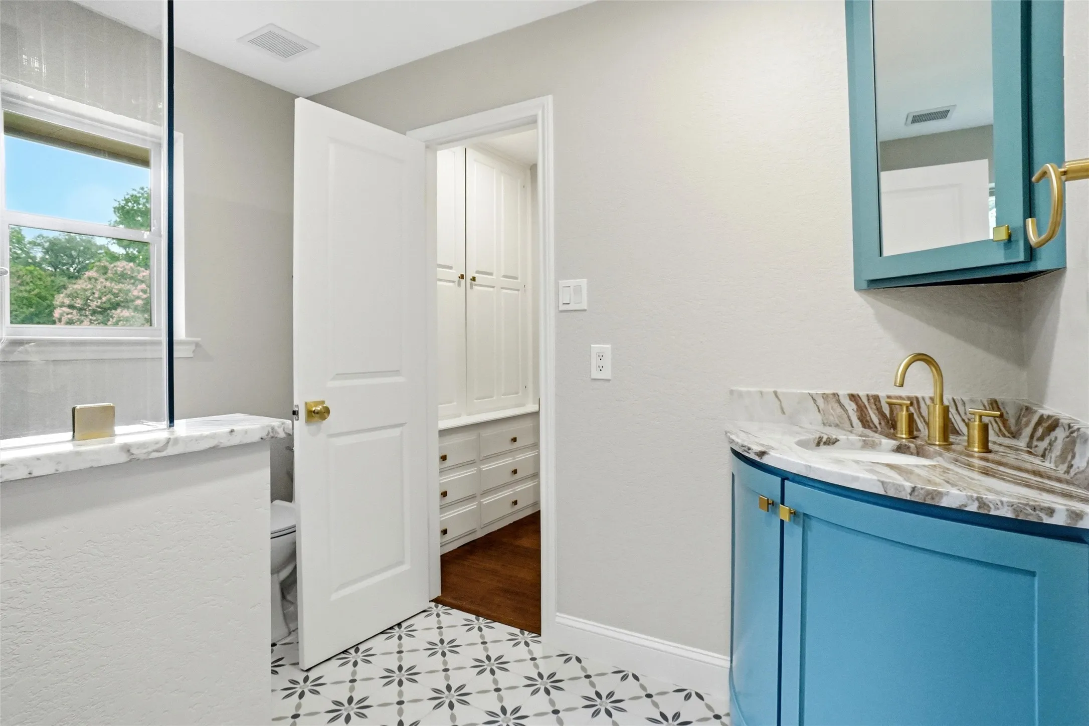 Cute secondary bathroom opens to dressing area, walk in closet and one bedroom; also opens to hallway for access to guests.