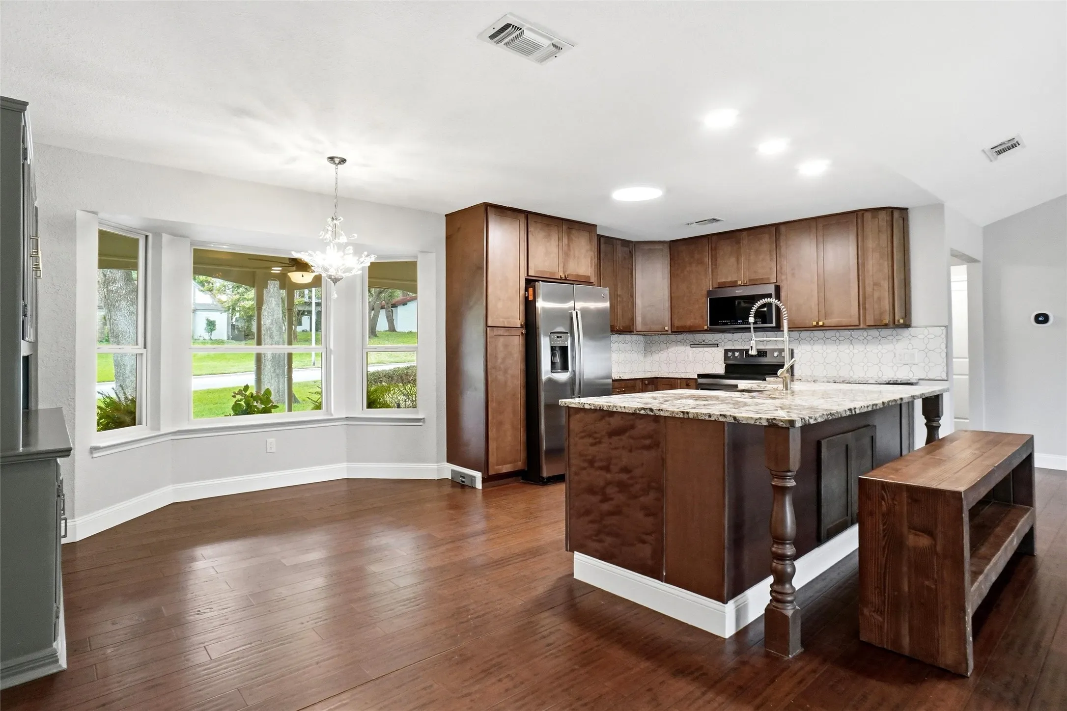 Bright open kitchen with gorgeous burled walnut cabinets, soft close drawers, and new stainless appliances.