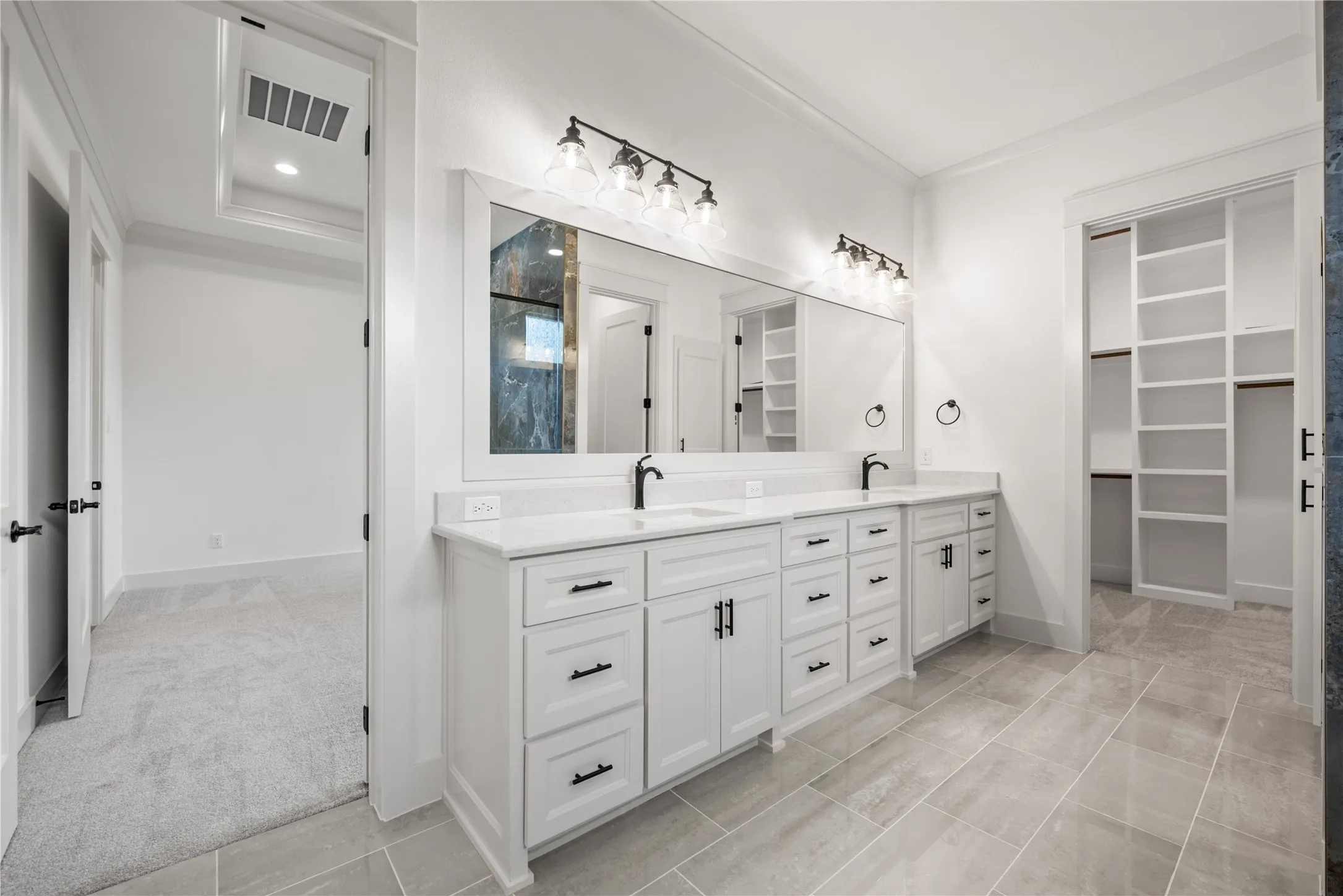 Double vanity with white cabinetry, quartz countertops, and matte black fixtures