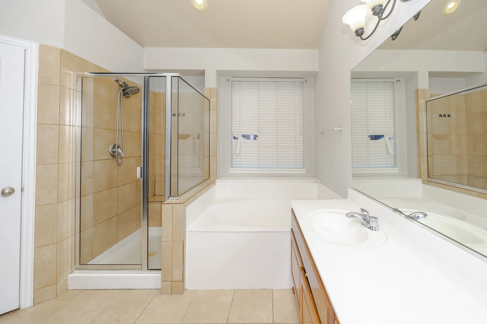 Walk-in shower with clear glass enclosure and tiled surround