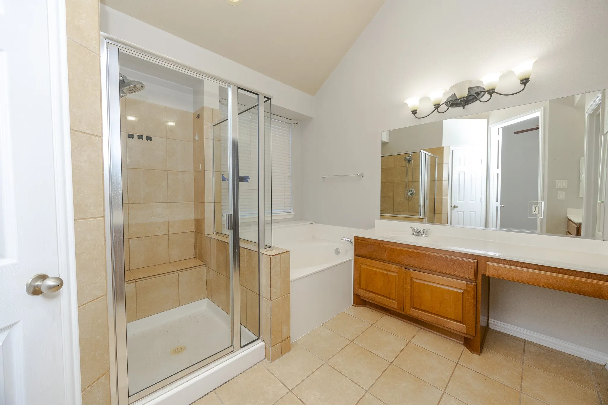 Shower enclosure with glass sliding doors, built-in bench, and tiled walls