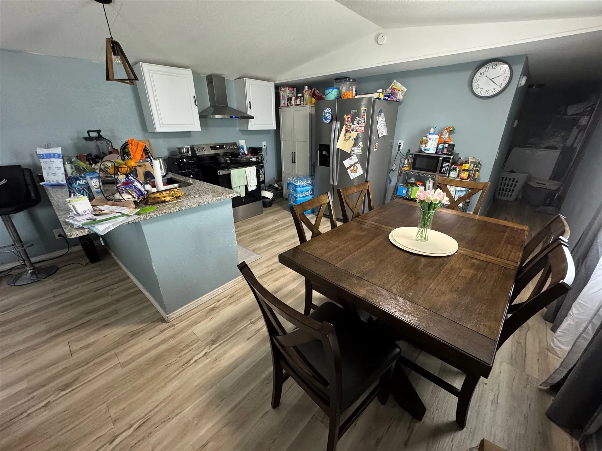 Integrated kitchen and dining area featuring wood-finish flooring